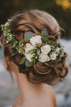 a woman with flowers in her hair and greenery on her head is wearing a flower crown