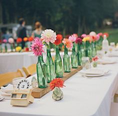 there are many vases with flowers in them on the table at this wedding reception