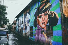 a mural on the side of a building with a woman's face painted on it