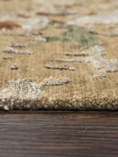 a close up view of a rug on a wooden floor, with the area marked in green and brown colors