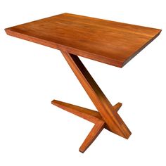 a wooden table with two crossed legs and a square top on an isolated white background