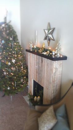 a living room with a christmas tree in the corner and a fire place next to it