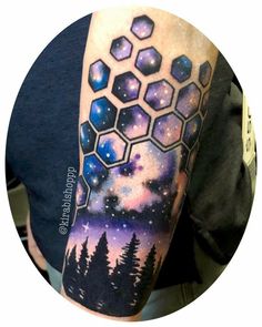 a man with a tattoo on his arm that has an image of the night sky and stars