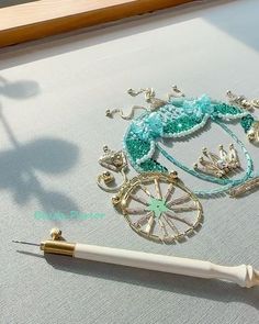 a pen sitting on top of a table next to an ornate brooch and necklace