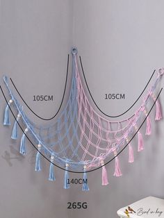 the wall hanging hammock is decorated with tassels