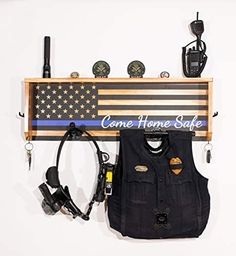 an american flag is hanging on the wall next to a police vest and other items