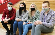 three people sitting on the steps wearing masks to protect them from the corona pandemic