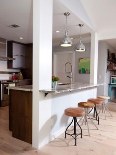 an image of a kitchen with stools in front of the island and bar area