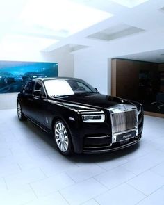 a black rolls royce parked in a white room