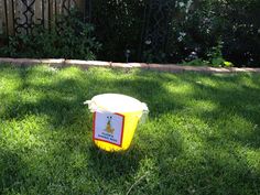 a yellow and white container sitting in the grass