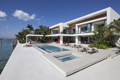 a large white house sitting next to the ocean