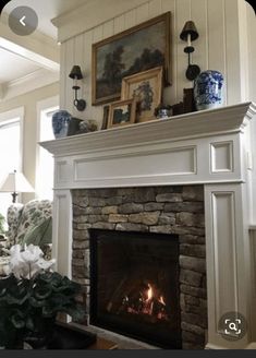 a living room with a fire place next to a painting on the wall above it