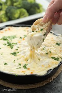 a person dipping some food into a skillet