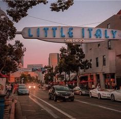 cars are driving down the street under a sign that reads, little italy san diego