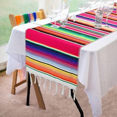 the table is set with colorful striped cloths and place settings for two people to sit at