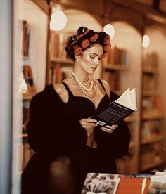 a woman reading a book in a library