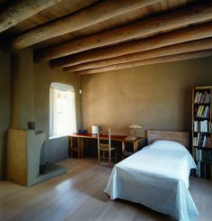 a bed sitting in a bedroom next to a book shelf