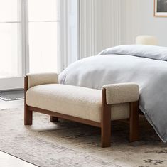 a bed with a footstool sitting on top of it