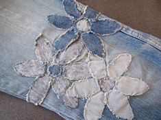 an old pair of jeans with embroidered flowers on them