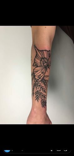 a woman's arm with tattoos on it and flowers in the middle of her arm