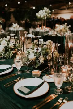 the table is set with plates, silverware, and candles for an elegant dinner