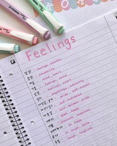 several pens are sitting on top of a notebook with the word feelings written in it