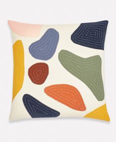 a decorative pillow with multicolored shapes on it