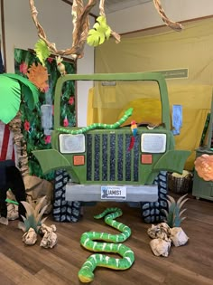 a green jeep parked in front of a bunch of fake snakes on the wooden floor