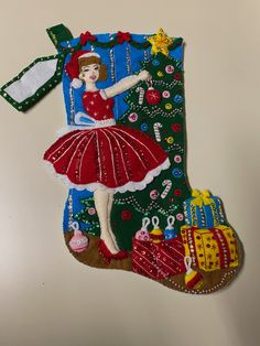 a christmas stocking ornament with a woman in a red dress hanging from it