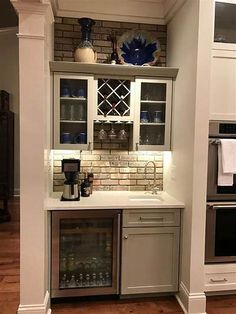 a kitchen with an oven, sink and wine cooler in it's cabinetry