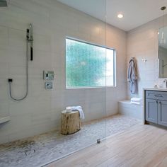 a large bathroom with white walls and wood flooring