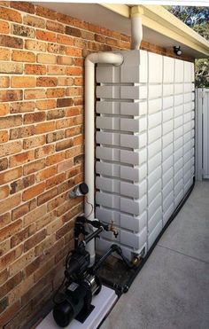 a water heater on the side of a brick building next to a white pipe