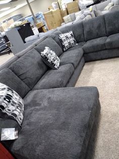 a large gray couch with pillows on it in a store