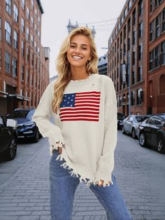 Stand out in style with our American Flag Relaxed Knit Sweater! This quirky and fun sweater features the iconic stars and stripes design, adding a playful touch to your look. Stay comfortable and show off your patriotic side with this cozy and unique sweater. Size Guide: Model is 5’7” tall, and has a 32.7” bust, 24.6”waist, & 36.2” hips. She is wearing a S / US 4 / AU 8. This sweater is true to size. Feature: Ripped crew neckline. Long sleeves. Ripped knit fabrication details. Not lined. Oversized Relaxed Fit. Material: 100% Acrylic. Care Instructions: Machine wash / Cold hand wash. Casual Crew Neck Sweater With Star Print, Casual Fall Sweater With Star Print, Fall Flag Print Long Sleeve Sweater, Long Sleeve Flag Print Sweater For Fall, Fall Long Sleeve Flag Print Sweater, Long Sleeve Tops For 4th Of July, Spring Americana Long Sleeve Tops, Oversized Crew Neck Tops For 4th Of July, Oversized Casual Tops For 4th Of July