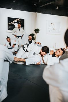 a group of men standing around each other in a room with one man on the ground