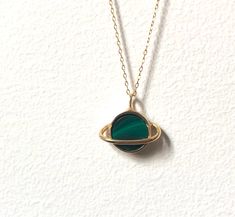 "This sweet pendant is made using a saturn setting that I handmade and had cast in brass, which is then plated in shiny 14k gold. A beautiful banded green malachite is set in the center, and it hangs on an 18\" 14k gold-filled chain. Perfect for that space loving gal. Also available with a lapis, abalone, opal/turquoise/copper mash up, moonstone, or turquoise." Oval Green Brass Jewelry, Handmade Green 14k Gold Necklace, Handmade 14k Gold Green Necklace, Tarnish Resistant Green Round Jewelry, Green Tarnish Resistant Round Jewelry, Handmade Gold Malachite Necklaces, Handmade Gold Necklaces With Malachite, Handmade Gold Necklace With Malachite, Malachite Pendant Jewelry As A Gift