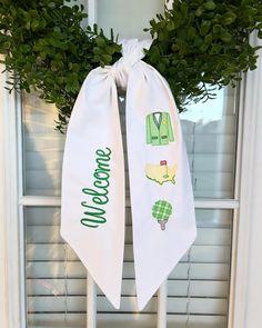 a white door hanger with green decorations on it