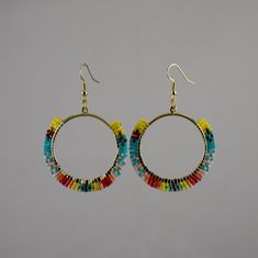 These hoop earrings each have three rows of brightly multi-colored seed beads on a fine metallic base. These earrings will grab people's attention.  The earrings are light-weight and have gold tone ear wires. The pendants are 1 and 11/16 inches wide and the drop length is approximately 2 and 3/8 inches in length.  Cute and Fun! Thanks for visiting my shop. Seed Bead Hoop Earrings, Yellow And Turquoise, Bead Hoop Earrings, Yellow Turquoise, Earrings Hoop, Beaded Hoop Earrings, Beaded Hoops, Seed Bead Earrings, Bead Earrings