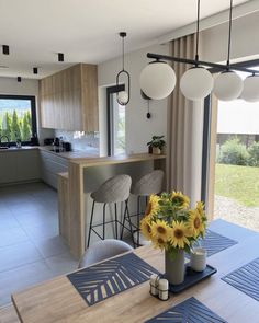 a vase with sunflowers sitting on top of a table next to a window