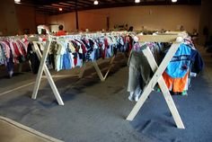 clothes are hanging on racks in an open space with other clothing and t - shirts