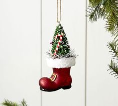 a christmas ornament hanging from a tree with candy canes in it's boot