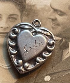 This is a sterling silver puffy heart from the 1940’s engraved with the name Jackie.Collect your friends and family names and monograms to create a really unique piece of jewelry that will become an heirloom passed down for generations. Remember to keep notes concerning the persons represented by the love token, puffy heart of charm. This is called the provenance of the piece and it increases the value of the item. More than a financial value, these types of heirlooms mean so much to those famil Vintage Personalized Jewelry For Collectors, Classic Double Heart Engraved Jewelry, Classic Engraved Double Heart Jewelry, Classic Heart-shaped Collectible Jewelry, Classic Heart Jewelry For Collectibles, Classic Heart Shaped Collectible Jewelry, Personalized Vintage Antique Silver Jewelry, Antique Silver Engraved Jewelry For Valentine's Day, Engraved Antique Silver Jewelry For Valentine's Day