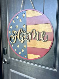 a wooden sign that says welcome hanging on a door with stars and an american flag