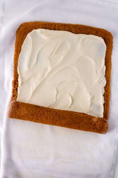 a piece of cake with white frosting sitting on top of a napkin