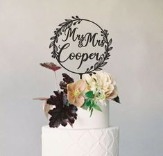 there is a wedding cake with flowers on the top and a sign that says mr and mrs cooper