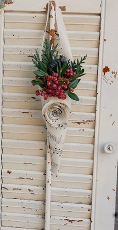 an old white door with a flower hanging from it's side and some writing on the front