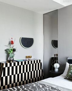 a black and white checkered bed spread in a room with mirrors on the wall