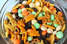 a glass bowl filled with halloween candy and pretzels