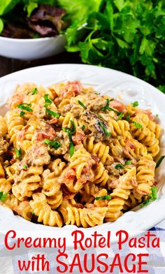 creamy rotini pasta with sausage and parsley in a white bowl on a table