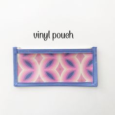 a pink and blue purse with the words vinyl pouch on it's front side